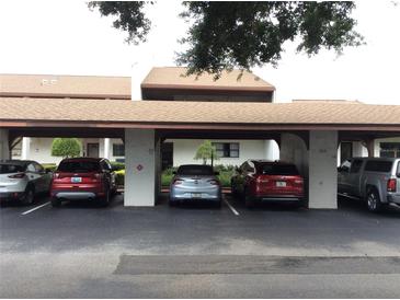 Covered parking area with assigned spaces near the building entrance, offering convenience and protection from the elements at 7614 Radcliffe Cir # B213, Port Richey, FL 34668