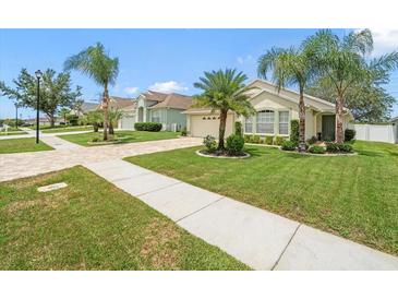 Charming single-story home featuring manicured landscaping, a paver driveway, and lush green lawns at 8457 Southern Charm Cir, Brooksville, FL 34613