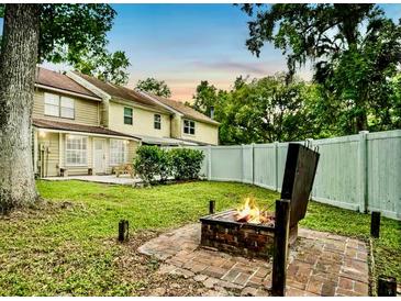 Inviting backyard featuring a fire pit and well-maintained lawn, perfect for outdoor relaxation and entertaining at 952 Coachlight Ln, Brooksville, FL 34601