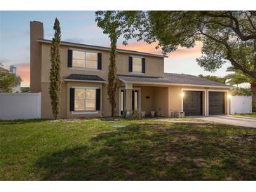 Charming two-story home with a two-car garage, a well-manicured lawn, and mature trees in a desirable neighborhood at 10091 Bannister St, Spring Hill, FL 34608
