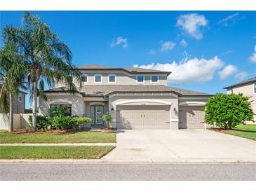 Charming two-story home with three-car garage, landscaped yard and a beautiful palm tree at 18558 Cortes Creek Blvd, Spring Hill, FL 34610