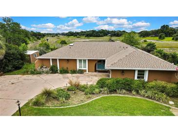Charming single story home with a lovely front yard, mature trees, and colorful landscape at 364 Waterfall Dr, Spring Hill, FL 34608
