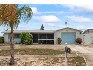 Charming single-story home featuring a screened-in porch and a delightful light blue garage door at 5321 Mosaic Dr, Holiday, FL 34690