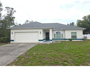 Charming single-story home featuring a two-car garage and tidy front yard with lawn at 5373 Frost Rd, Spring Hill, FL 34606
