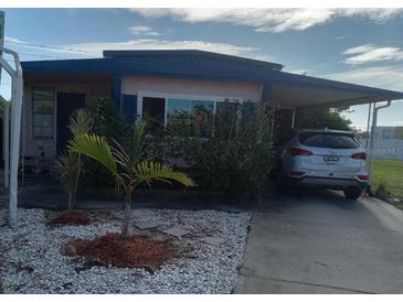 Cozy home featuring a charming carport and tropical landscaping with youthful palm trees in a quaint yard at 5494 Fairfield S Ave # 9, Gulfport, FL 33707