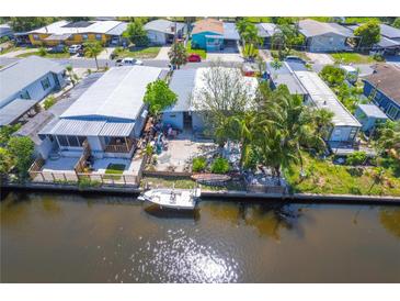 Waterfront property with boat, canal access, and views of neighboring homes in a tranquil community setting at 5824 Portsmouth Dr, Tampa, FL 33615