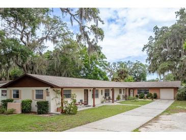 Charming multi-Gathering home featuring lush landscaping, mature trees, and covered front patios at 6019 Wyoming Ave, New Port Richey, FL 34653