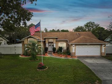 Charming single-Gathering home with manicured lawn and an American flag waving proudly in the front yard at 8324 Nightingale Rd, Weeki Wachee, FL 34613