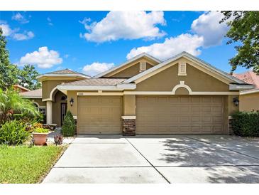 Inviting home featuring a three-car garage, manicured landscaping, and a neutral color palette at 11101 Ragsdale Ct, New Port Richey, FL 34654