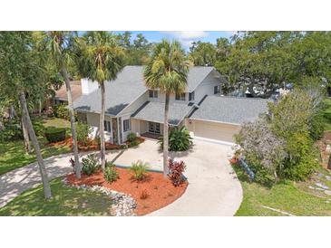 Beautiful two-story home featuring lush landscaping, a circular driveway, and a two-car garage at 4439 Reeves Rd, New Port Richey, FL 34652