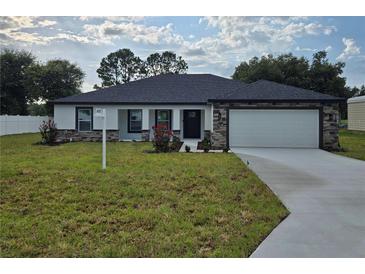 Beautiful single-story home with manicured lawn, two-car garage, stone accents and neutral paint at 5555 Baffin Cir, Spring Hill, FL 34606