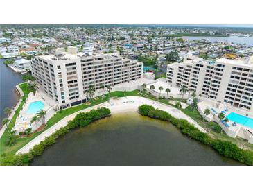 Stunning aerial view of condo community featuring lush landscaping, private beach, and inviting swimming pools at 6035 Sea Ranch Dr # 410, Hudson, FL 34667
