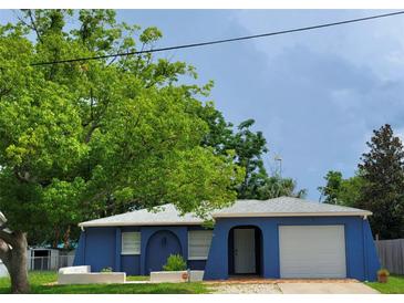 Charming blue one-story home featuring an attached garage and arched entry at 8504 Lafitte Dr, Hudson, FL 34667