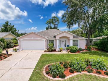 Charming single-story home featuring a well-manicured lawn and a two-car garage at 9431 Spring Hill Dr, Spring Hill, FL 34608