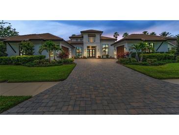 A stunning home featuring a paver driveway, manicured landscaping, and elegant design, perfect for luxurious living at 9704 Milano Dr, Trinity, FL 34655