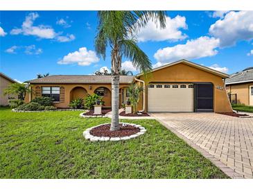 Charming single-story home with a well-manicured lawn, beautiful landscaping, and a brick driveway at 10924 Archway Ave, Hudson, FL 34667
