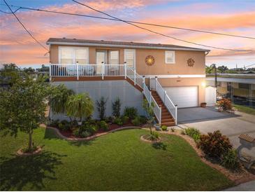 Charming raised bungalow with manicured lawn, lovely landscaping, and a covered front porch at 13027 Beacon Ct, Hudson, FL 34667