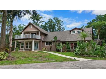 Charming two-story home featuring a welcoming front yard, upper deck, and lush landscaping at 2202 Amity Ct, New Port Richey, FL 34655