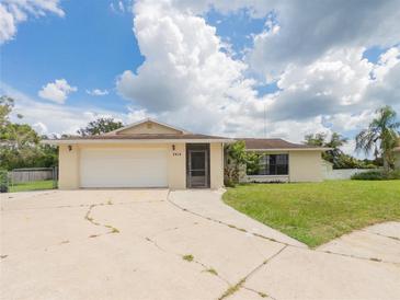 Charming single Gathering home with a well-maintained front yard and attached two-car garage at 2414 San Luis Rd, Holiday, FL 34691