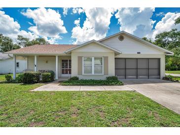 Charming single-story home featuring a screened-in garage, well-manicured lawn, and inviting curb appeal at 4646 Lacrosse Ct, New Port Richey, FL 34655