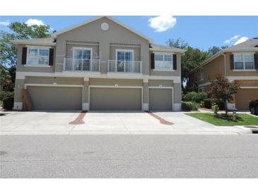 Charming townhome showcasing three garage doors and second-story balconies at 7650 Red Mill Cir, New Port Richey, FL 34653