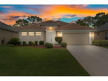 Charming single-story home with a well-manicured lawn and a two-car garage at sunset at 9149 Penelope Dr, Weeki Wachee, FL 34613
