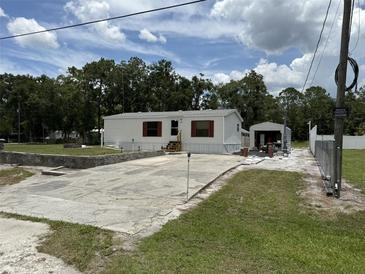 Inviting single-story home with white siding, red shutters, and a spacious driveway for ample parking at 10654 Holgate St, New Port Richey, FL 34654