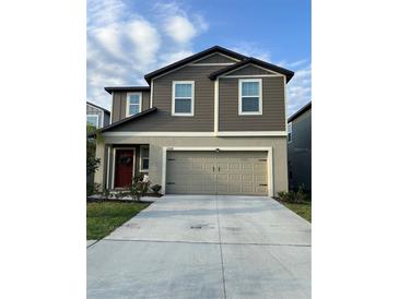 Inviting two-story home featuring a neutral color palette, a two-car garage, and a well-maintained front yard at 22289 Nebula Way, Land O Lakes, FL 34637