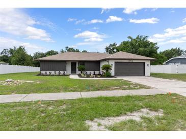 Charming single story home featuring a neatly landscaped front yard and an attached garage at 3498 Plaza Ave, Spring Hill, FL 34608