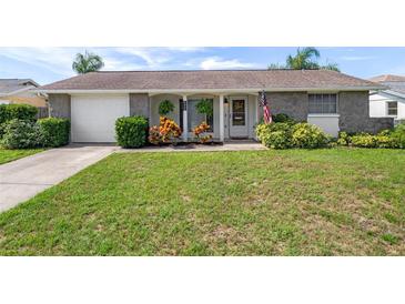 Charming single-story home with a lush green lawn and beautiful stone accents at 6930 El Camino Paloma St, Port Richey, FL 34668