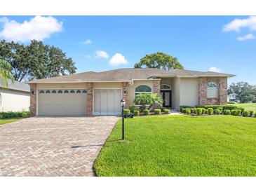 Charming single-story home features a well-manicured lawn, brick accents, and a spacious driveway leading to the garage at 7328 Blue Skies Dr, Spring Hill, FL 34606