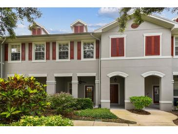 Charming townhouse exterior with red shutters, covered porch, and landscaped front yard at 9420 Georgian Park Ln # 106, Tampa, FL 33626