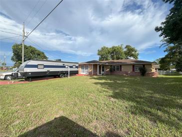 Charming single-story home with a well-manicured lawn and a convenient RV parking space at 10458 Clingman St, Spring Hill, FL 34608