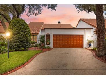 Charming home featuring a well-manicured lawn, warm-toned garage door, and welcoming curb appeal at 11505 Cerca Del Rio, Temple Terrace, FL 33617