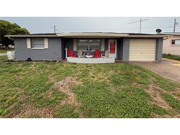 Charming single-story home with a cozy front yard and inviting front patio seating area at 5208 Chet Dr, New Port Richey, FL 34652