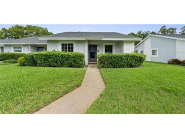 Charming single-story home with a well-manicured lawn and lush green hedges along the walkway at 7700 Danube Dr # 7700, Hudson, FL 34667