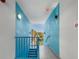 Bright hallway with blue walls and modern metal railings leading to an outdoor view at 1558 4Th St # 406, Sarasota, FL 34236