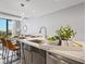 Modern kitchen island with marble countertop, stylish lighting, and stainless steel appliances at 1558 4Th St # 406, Sarasota, FL 34236