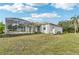 A single Gathering home with a green grass backyard and full screened in pool enclosure, with a bright blue sky above at 2781 Shady Ave, North Port, FL 34286