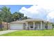 Single story home with white columns, neutral color palette, well manicured lawn, and attached two car garage at 2781 Shady Ave, North Port, FL 34286