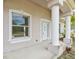 Inviting front porch featuring sturdy columns, a window, and a white front door at 2781 Shady Ave, North Port, FL 34286