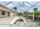 Enclosed pool area with a drained pool, patio, and a screened enclosure offers potential for outdoor enjoyment at 2781 Shady Ave, North Port, FL 34286