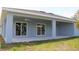 Covered back porch with ceiling fans, offering an inviting outdoor space connected to the lush backyard at 310 Day Break Cir, Port Charlotte, FL 33954
