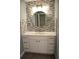 Bathroom vanity with marble countertop, sink, ample cabinet space and a decorative tile backsplash at 310 Day Break Cir, Port Charlotte, FL 33954