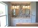 Modern bathroom featuring a double vanity with round mirrors and stylish mosaic backsplash at 310 Day Break Cir, Port Charlotte, FL 33954