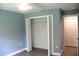 Bedroom with closet with bi-fold doors, showing a bright space with light blue walls and gray flooring at 310 Day Break Cir, Port Charlotte, FL 33954