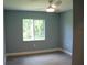 Bright bedroom with a ceiling fan, neutral paint, gray flooring, and window with a view to the backyard at 310 Day Break Cir, Port Charlotte, FL 33954
