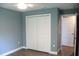 Clean bedroom with standard closet, light blue walls, gray flooring, and entry doorway to hallway at 310 Day Break Cir, Port Charlotte, FL 33954