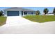 Charming one-story home featuring a blue garage door, light blue exterior, and decorative white-tiled driveway at 310 Day Break Cir, Port Charlotte, FL 33954
