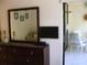 Bedroom with dresser, mirror, and small TV; access to a balcony at 4450 47Th W Ave # 202, Bradenton, FL 34210